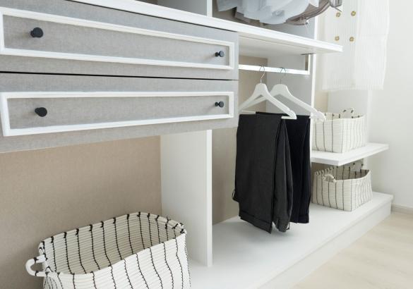 A clean and minimally outfitted walk-in closet space decorated in white and grey.