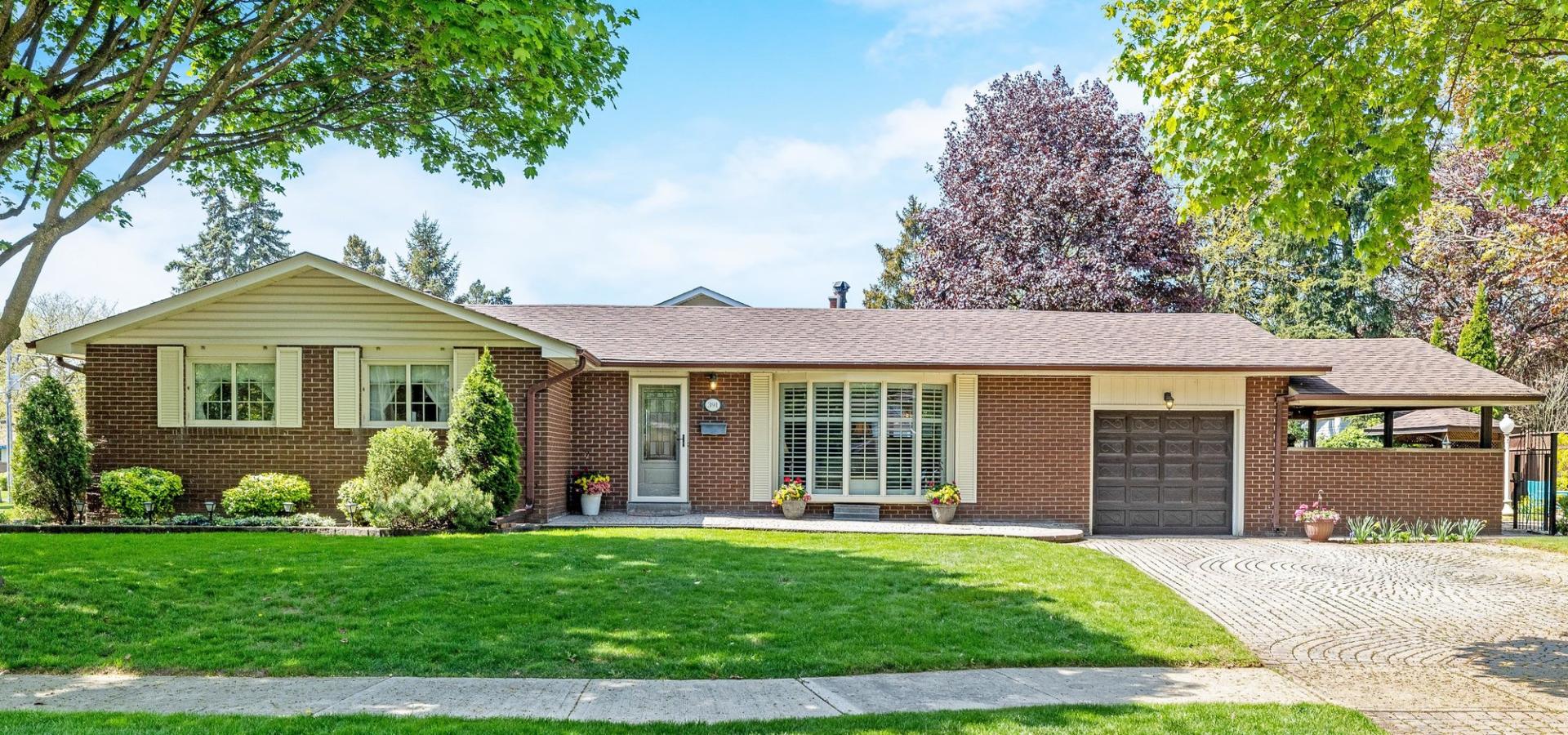 Beautiful brick bungalow with great curb appeal, surrounded by mature trees
