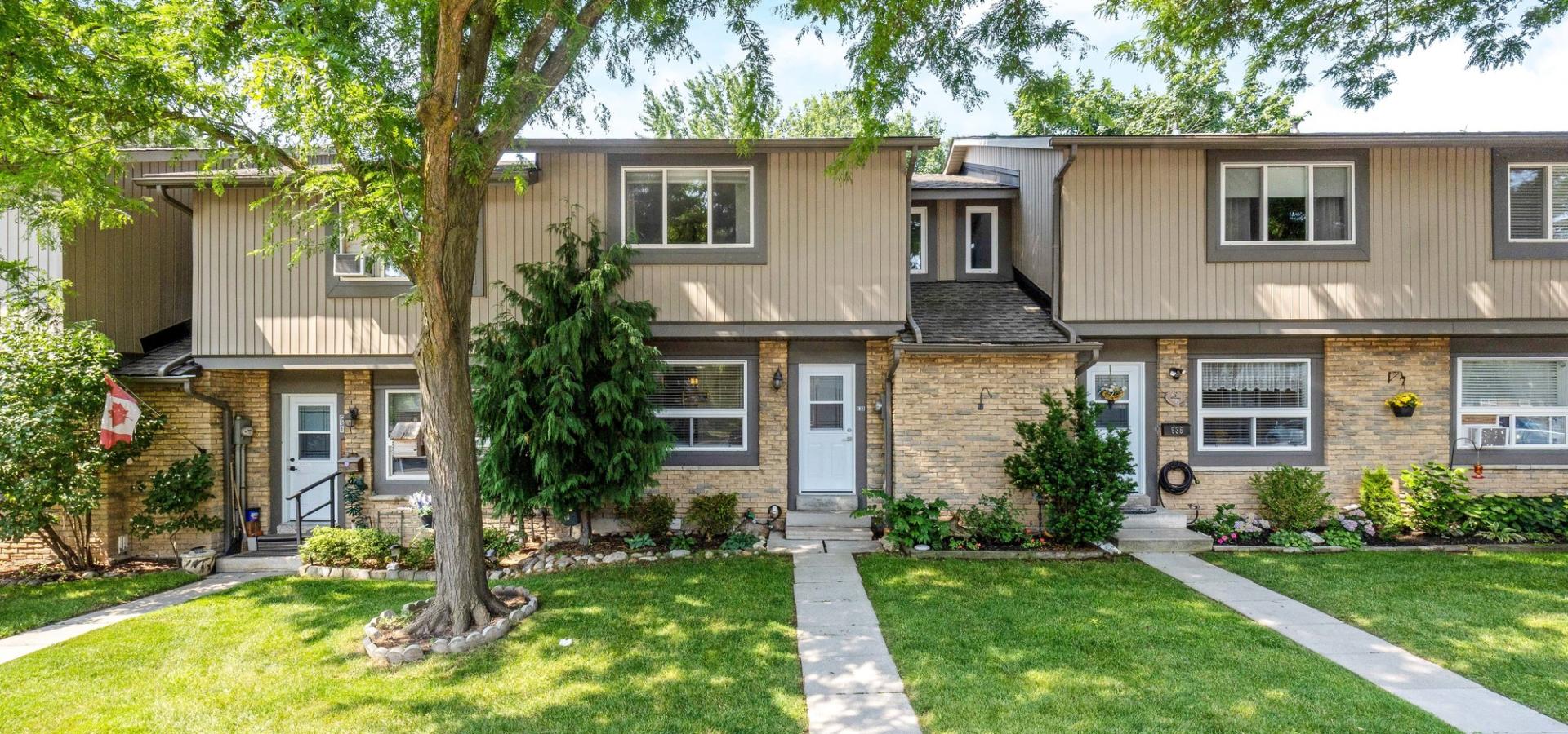 Brick and siding townhome with mature trees
