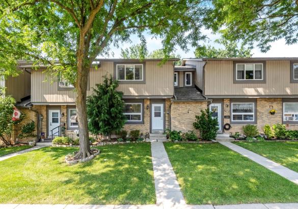 Brick and siding townhome with mature trees